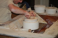  A wet sponge helps him force the raw, wet porcelain into the mold.